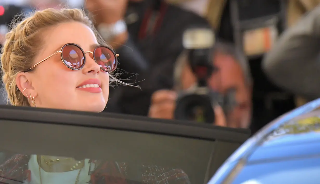 Aktris AS Amber Heard masuk ke dalam mobil saat tiba untuk menghadiri malam pembukaan Festival Film Cannes ke-72 di Prancis (13/5/2019). Mantan istri Johnny Depp ini tampil gaya dengan kaos putih, skinny jeans dan jaket multi-warna, dihiasi dengan jumbai berbulu.
(AFP Photo/Loic Venance)