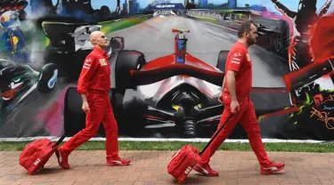 Anggota tim Ferrari tiba untuk mengepak peralatan mereka setelah Formula 1 Australia dibatalkan di Melbourne, Jumat (13/3/2020). F1 Australia batal digelar karena virus corona COVID-19. (William WEST/AFP)