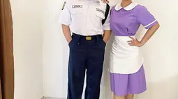 Adam Suseno kali ini menjadi petugas keamanan alias sekuriti di sebuah rumah mewah. Ia tampil rapi dengan kemeja putih lengan pendek dan celana panjang biru dongker. Sang Ratu Ngebor rupanya jadi asisten rumah tangga dengan atasan dan rok warna kecubung. Agar tak terkesan monoton, pada bagian kerah, lengan, dan celemeknya diwarnai putih. (Foto: Dok. Instagram @inul.d)