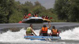 Umat muslim merayakan liburan Idul Fitri dengan rafting menyusuri Sungai Hasbani, Anak Sungai Yordan, di Kfar Blum, Israel, Rabu (27/5/2020). Pemerintah Israel mengurangi pembatasan aktivitas terkait pandemi virus corona COVID-19. (JALAA MAREY/AFP)