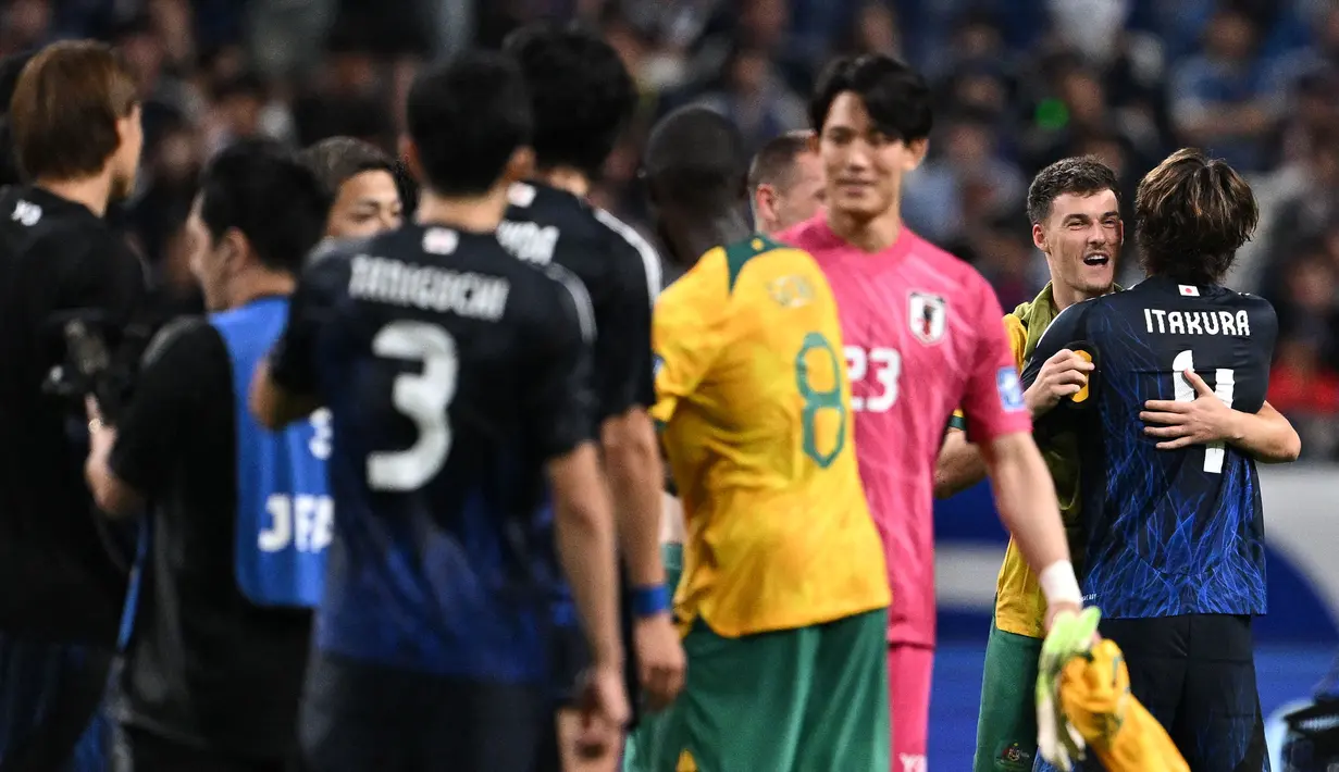 Pemain Jepang, Ko Itakura berpelukan dengan pemain Australia saat laga lanjutan Grup C Kualifikasi Piala Dunia 2026 di Saitama Stadium, Jepang, Selasa (15/10/2024). (AFP/Philip Fong)