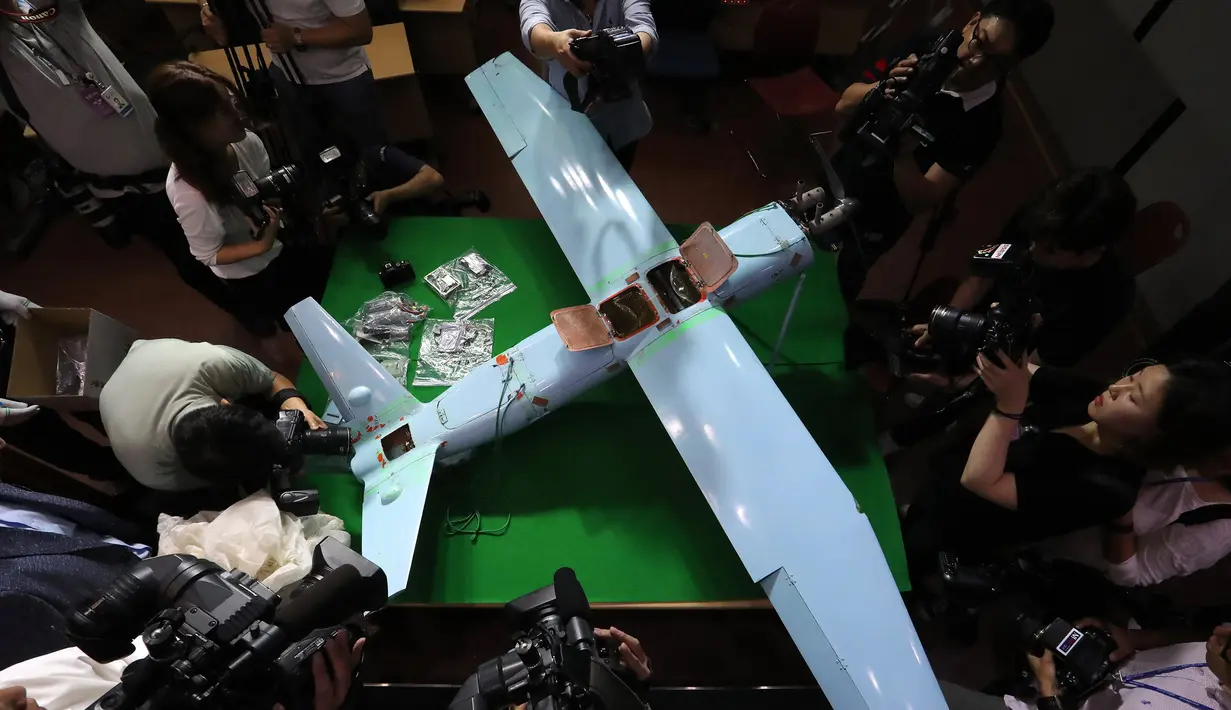 Awak media mengambil gambar pesawat tak berawak atau drone milik Korea Utara yang diperlihatkan di Kementerian Pertahanan Korea Selatan, Seoul, Rabu (21/6). Drone itu ditemukan jatuh di sebuah gunung dekat perbatasan zona demiliterisasi. (YONHAP / AFP)
