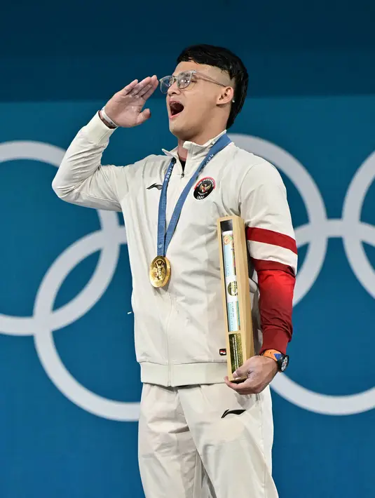 Meski gagal mengangkat beban seberat 155 kg pada percobaan angkatan pertama snatch, Rizki Juniansyah bangkit dan berhasil sukses mengangkat beban seberat 155 kg pada angkatan kedua. Di clean and jerk, Juniansyah langsung berhasil melakukan angkatan pertamanya seberat 191 kg. (Miguel MEDINA/AFP)