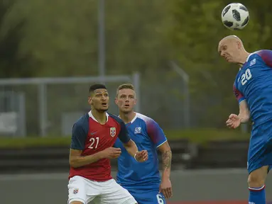 Pemain Islandia, Emil Hallfredsson (kanan) menghalau bola dari kejaran pemain Norwegia pada laga uji coba di Reykjavik, Islandia, (2/6/2018). Islandia kalah dari Norwegia 2-3. (AFP/Haraldur Gudjonsson)