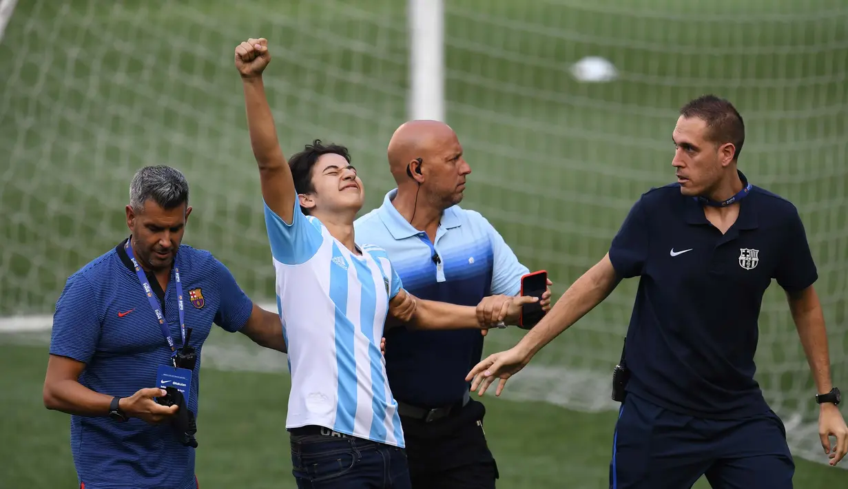 Seorang  fans saat diamankan petugas saat sesi latihan tim Barcelona di Red Bull Arena di Harrison, New Jersey, (21/7). Barcelona akan berhadapan dengan Juventus pada ICC 2017. (AFP Photo/Jewel Samad) 