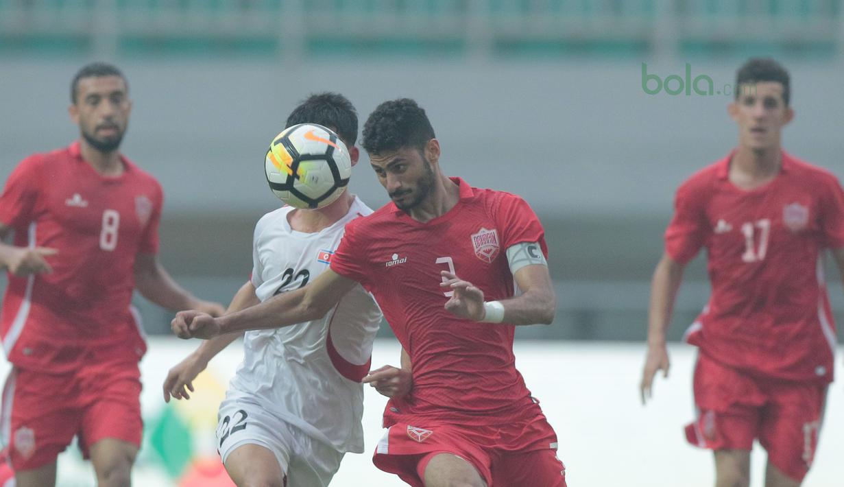 Pemain Bahrain U-23, Sayed Mohamed Shubbar (kanan) menghalau bola dari kejaran pemain Korea Utara U-23 pada laga PSSI Anniversary Cup 2018 di Stadion Pakansari, Bogor, (03/5/2018). Bahrain menang 4-1. (Bola.com/Nick Hanoatubun)