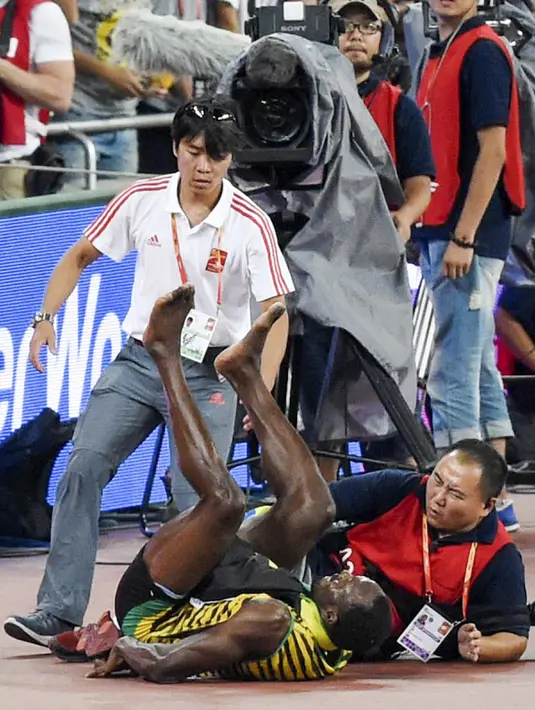 Pelari Jamaika, Usain Bolt jatuh usai tertabrak kameramen yang mengendarai skuter saat dirinya melakukan selebrasi kemenangan meraih medali emas di nomor 200 meter pada Kejuaran Dunia Atletik di Beijing, Kamis (27/8). (REUTERS/Stringer CHINA OUT)