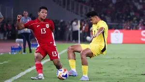 Bek Timnas Indonesia U-23, Alfharezzi Buffon mencoba menahan pegerakan pemain Timnas Malaysia U-23 dalam laga Grup A Piala AFF U-23 2025 di Stadion Utama Gelora Bung Karno Jakarta, Senin (21/7/2025). (Bola.com/Abdul Aziz).
