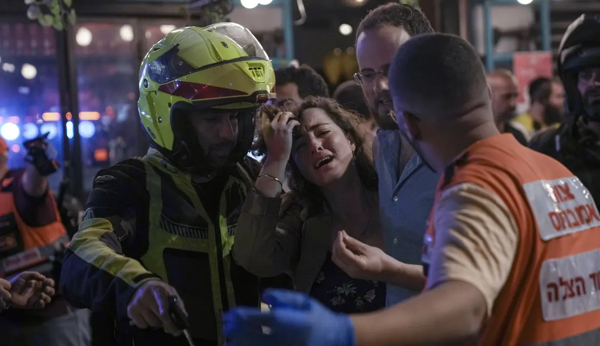 Seorang wanita menangis dekat lokasi penembakan di Tel Aviv, Israel, 7 April 2022. Penembakan terjadi di daerah ramai dengan beberapa bar dan restoran. (AP Photo/Ariel Schalit)