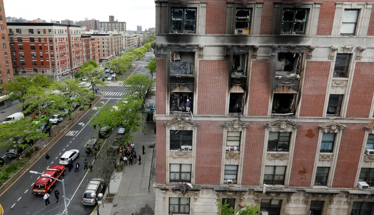 Petugas pemadam kebakaran mengumpulkan puing-puing sisa kebakaran yang terjadi di sebuah apartemen di kawasan Harlem, New York, Amerika Serikat, Rabu (8/5/2019). Keenam korban dinyatakan meninggal di tempat kejadian. (AP Photo/Richard Drew)
