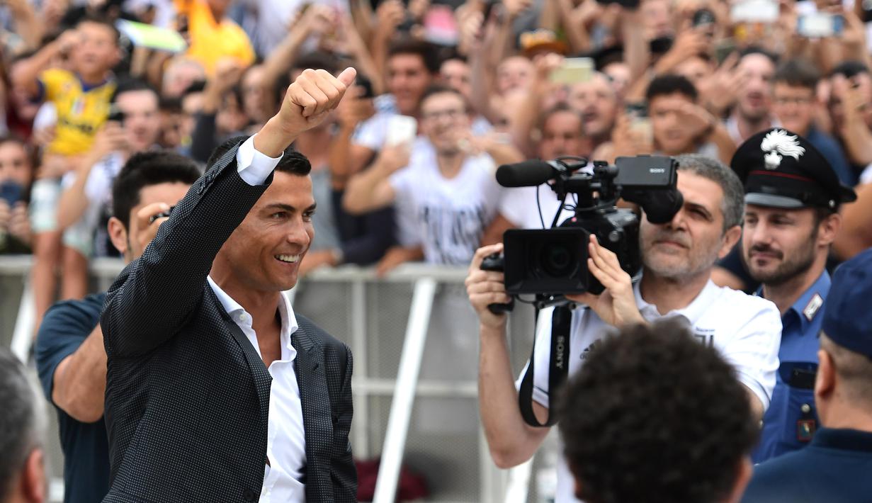 Bintang baru Juventus, Cristiano Ronaldo, menyapa suporter saat tiba untuk menjalani tes kesehatan di area Stadion Allianz, Turin, Senin (17/7/2018). CR 7 hijrah dari Real Madrid ke Juventus. (AFP/Miguel Medina)