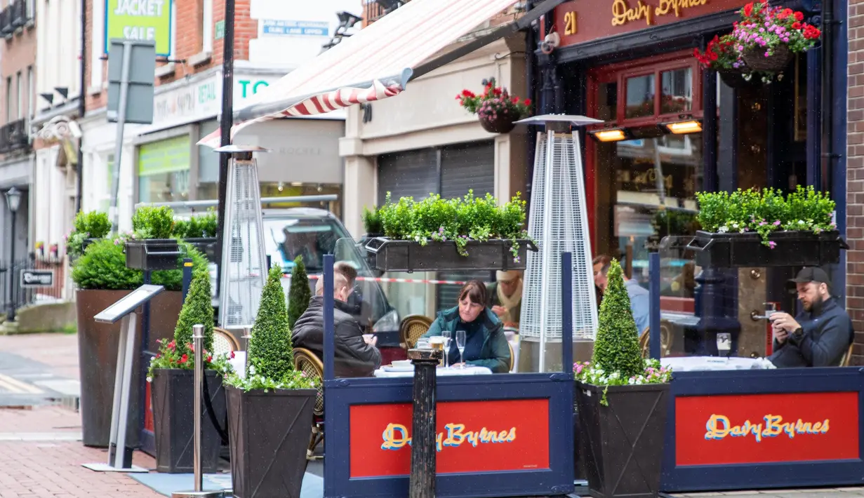 Sejumlah orang menyantap hidangan di luar bar yang kembali buka di Dublin, Irlandia, Senin (29/6/2020). Irlandia memasuki fase ketiga pencabutan pembatasan COVID-19, dengan mengizinkan lebih banyak bisnis kembali beroperasi dan memberikan kebebasan pergerakan lebih besar kepada masyarakat. (Xinhua)