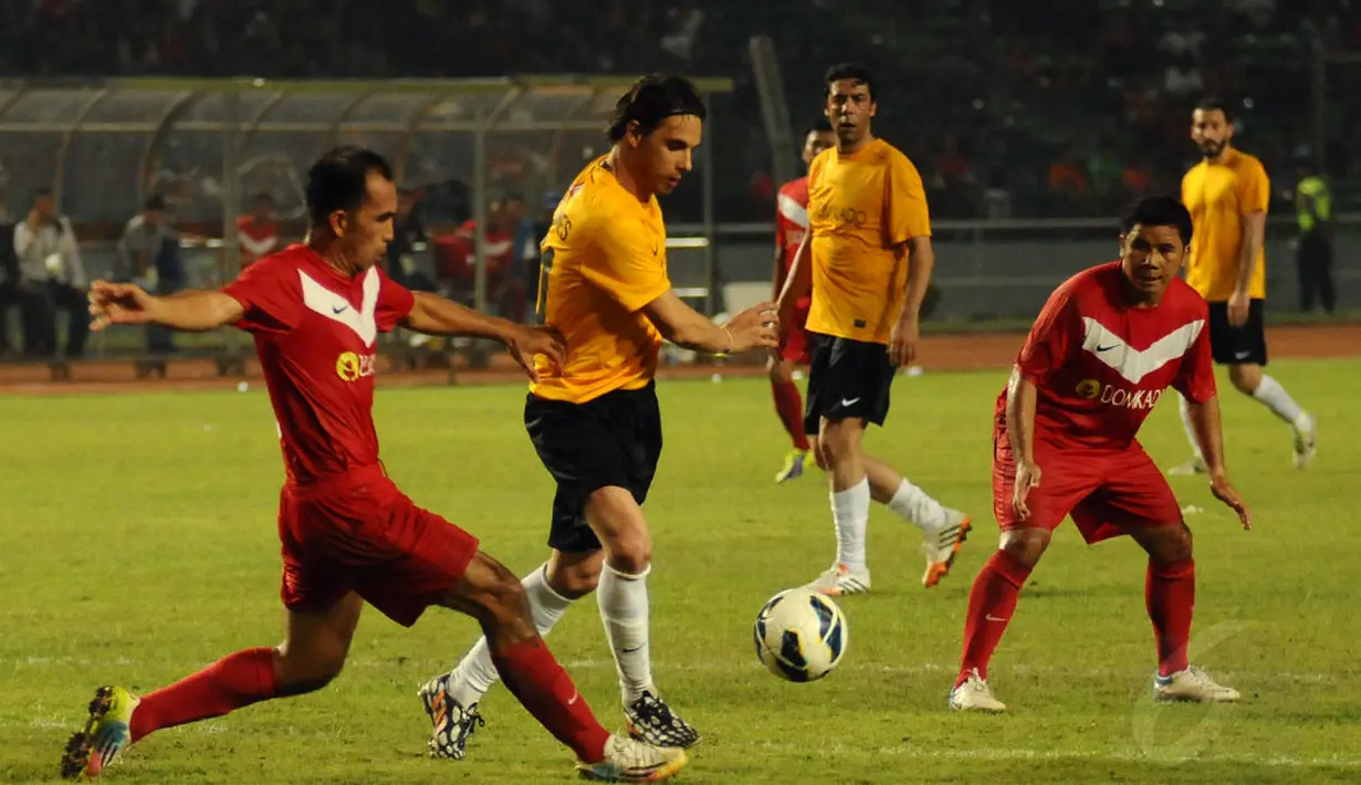 Dua pemain Legenda Indonesia mencoba menahan laju serangan tim World Football Legends yang dibangun mantan pesepakbola Portugal, Nuno Gomes saat berlaga di Stadion GBK Jakarta, (7/6/2014). (Liputan6.com/Helmi Fithriansyah)