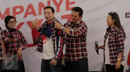 Cagub DKI Jakarta Basuki Tjahaja Purnama atau Ahok memakaikan kemeja kotak-kotak ke artis peran Ari Wibowo disaksikan Ira Wibowo, sebelum menyampaikan dukungan mereka ke Ahok-Djarot di Rumah Lembang, Jakarta, Kamis (24/11). (Liputan6.com/Gempur M Surya)