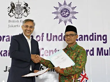 Dubes Inggris untuk Indonesia Moazzam Malik (kiri) bersama Ketua Umum PP Muhammadiyah Haedar Nasir melakukan penandatanganan nota kesepahaman di Jakarta, Senin (16/5). (Liputan6.com/Immanuel Antonius)