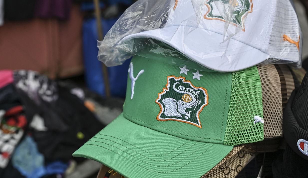 Topi berlogo Pantai Gading dijual di salah satu pasar Abidjan, pusat kota Pantai Gading menjelang Piala Afrika 2023 pada Sabtu (06/01/2024) waktu setempat.. (AFP/Issouf Sanogo)