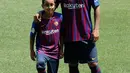 Pemain baru Barcelona, Arturo Vidal berpose dengan putranya Alonso Vidal selama presentasi dirinya di stadion Camp Nou, Spanyol, (6/8). Vidal dibeli Barcelona dari klub Jerman, Bayern Munchen. (AP Photo/Manu Fernandez)