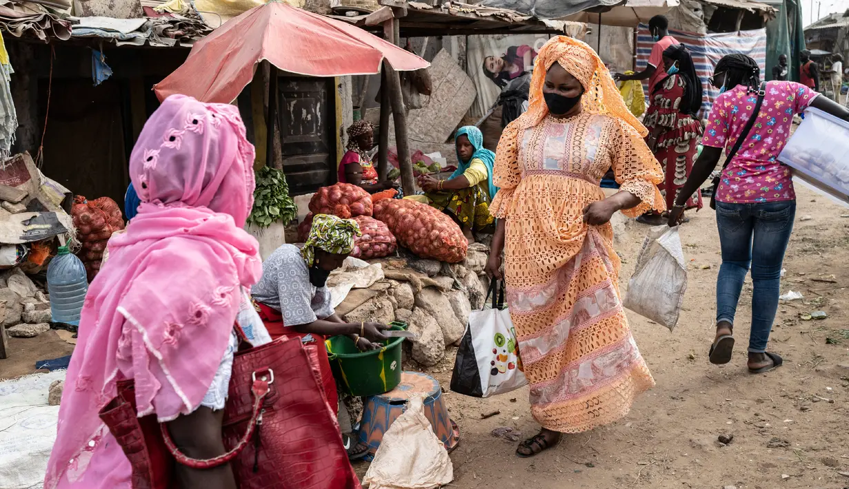 Mame Sey, istri Bara Tambedou, mengenakan masker saat ke pasar membeli makanan pada bulan suci Ramadan, di Dakar, Senegal, 25 April 2020. Tahun ini, banyak keluarga menjalankan Ramadan di rumah dengan larangan pertemuan publik dan jam malam untuk menekan penyebaran Covid-19. (AP/Sylvain Cherkaoui)