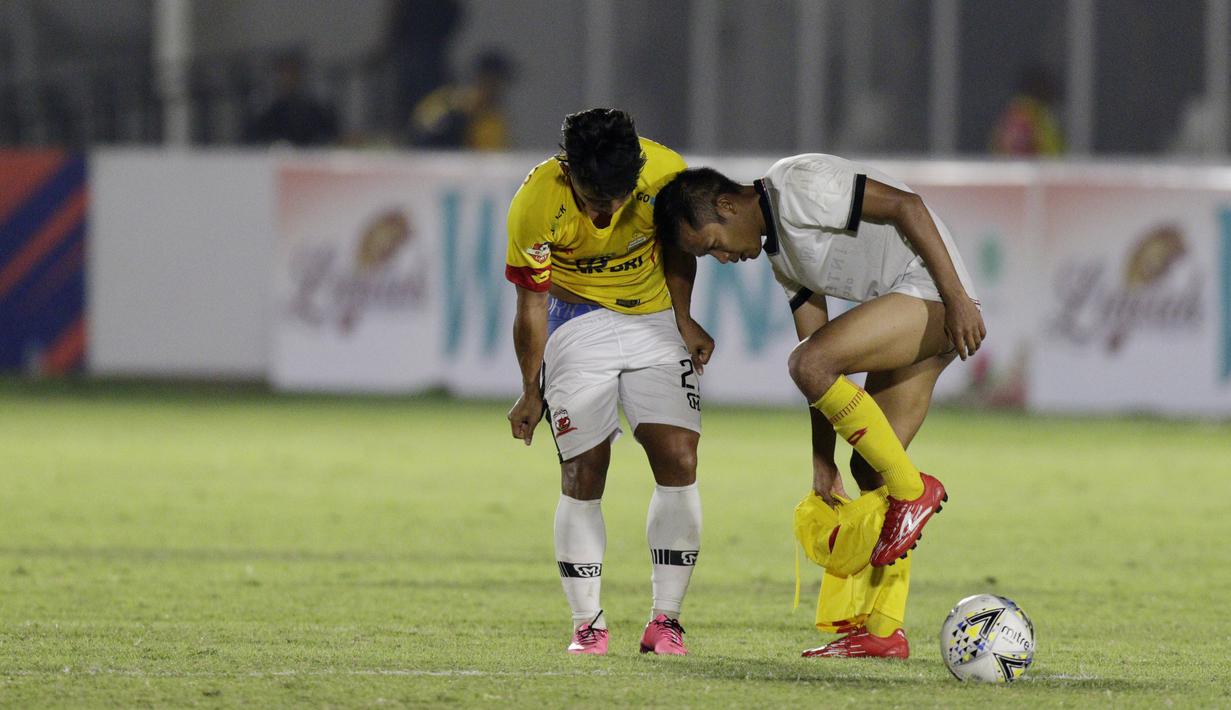 Gelandang Madura United, Andik Vermansah, bertukar jersey dan celana dengan gelandang Bhayangkara FC, Wahyu Suboseto, pada laga Liga 1 2019 di Stadion Madya, Jakarta, Senin (5/8). Kedua tim bermain imbang 1-1. (Bola.com/M iqbal Ichsan)