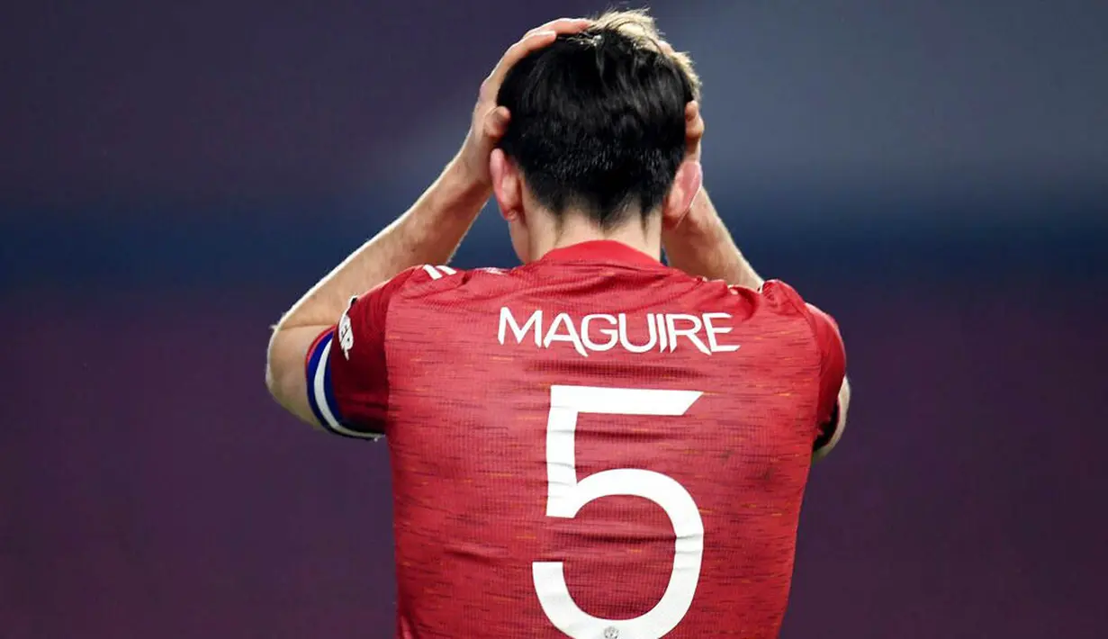 Bek Manchester United, Harry Maguire, memegang kepala usai ditaklukkan Manchester City pada laga Piala Liga Inggris di Stadion Old Trafford, Rabu (6/1/2021). City menang dengan skor 2-0. (Peter Powell/Pool via AP)