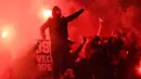 Pendukung Paris Saint-Germain menyalakan suar atau flare saat pertandingan melawan Real Madrid di stadion Parc des Princes di Paris (6/3). Dalam pertandingan ini PSG kalah 1-2 atas Real Madrid. (AFP Photo/Franck Fife)