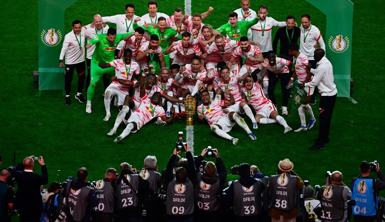 Pemain Leipzig merayakan kemenangan bersama trofi DFB Pokal atau Piala Liga Jerman usai mengalahkan SC Freiburg pada partai final yang berlangsung di Stadion Olimpiade di Berlin, Jerman, Sabtu, 21 Mei 2022 waktu setempat. Die Bullen berhasil menang lewat babak adu penalti dengan skor 4-2 usai laga berjalan imbang 1-1. (AFP/John Macdougall)