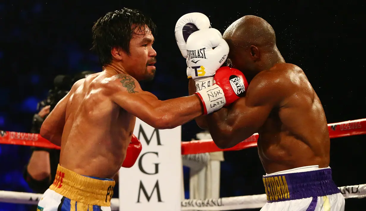 Petinju Manny Pacquiao (kiri) saat melayangkan pukulan kepada lawannya Timothy Bradley di MGM Grand Garden Arena, Las Vegas, AS, (9/4). (Mark J. Rebilas-USA TODAY Sports)