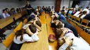 Anak-anak menutupi kepala dengan kedua tangan ketika latihan keamanan di Sekolah Nomor 8, Desa Sartana wilayah timur Ukraina, 2 Oktober 2018. Mereka mempraktikkan yang harus dilakukan jika sekolah mereka menjadi target serangan. (Aleksey FILIPPOV/AFP)