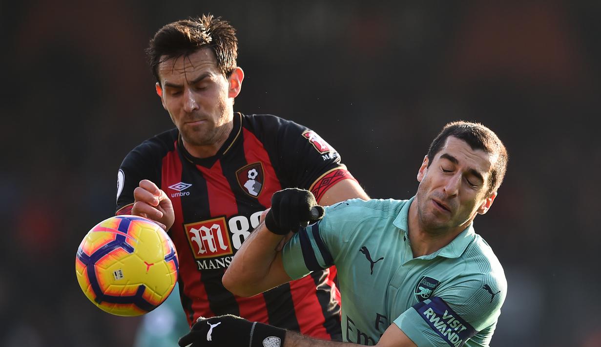 Aksi Henrikh Mkhitaryan berduel dengan pemain Bournemouth, Charlie Daniels pada laga lanjutan Premier League yang berlangsung di stadion Dean Court, Inggris, Minggu (25/11).  Arsenal menang 2-1. (AFP/Glyn Kirk)
