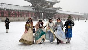 Pengunjung yang mengenakan pekaian tradisional "Hanbok" di salju berjalan melalui Istana Gyeongbok, istana kerajaan utama selama Dinasti Joseon dan salah satu landmark terkenal Korea Selatan di Seoul, Korea Selatan, 15 Desember 2022. (AP Photo/Ahn Young-joon)
