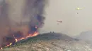 Sejumlah helikopter dikerahkan untuk memadamkan kebakaran hutan di Benitatxell dekat Alicante, Spanyol, Senin (5/9). Sedikitnya 20 rumah hangus dilalap si jago merah dari kebakaran hutan tersebut. (REUTERS / Heino Kalis)