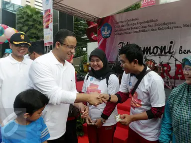Menteri Pendidikan & Kebudayaan, Anies Baswedan secara simbolis memberikan kartu ATM Bank bjb di Senayan, Jakarta, Minggu (24/04). Bank bjb memberikan apresiasi berupa kartu bjb cinta guru. (Liputan6.com/Fery Pradolo)  