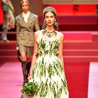 Seorang model berpose di atas catwalk dengan membawa tas besar mirip tas pasar dan mengisinya dengan sayuran untuk koleksi Dolce & Gabbana Spring/Summer 2018 di Milan Fashion Week, Minggu (24/9). (AFP PHOTO / Andreas SOLARO)