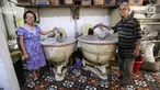 Rosani, generasi ketiga (kiri) dan suaminya Pararto Widjajakusuma (kanan) berfoto bersama di antara adonan kue peninggalan Belanda di Toko Roti GO, Purwokerto, Jawa Tengah, Senin (22/4). Toko roti yang berdiri sejak tahun 1898 itu telah memasuki usia ke 121 tahun. (Liputan6.com/Fery Pradolo)