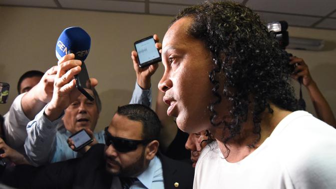 Mantan pemain timnas Brasil, Ronaldinho tiba memberikan keterangan di Asuncion's Justice Palace, ibu kota Paraguay, Jumat (6/3/2020). Ronaldinho bersama saudara laki-lakinya berurusan dengan pihak berwenang Paraguay karena menggunakan paspor palsu untuk memasuki negara itu. (Norberto DUARTE/AFP)