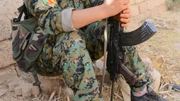 Prajurit perempuan Yazidi dari Unit Perlawanan Sinjar (YBS) memegang senapan AK47 saat Berpatroli penjagaan wilayah Pegunungan Sinjar dari serangan militan ISIS di Irak (6/6). (Reuters/Stringer)