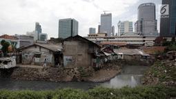 Anak-anak sekolah melintas di Kampung Kuningan Timur, Jakarta, Kamis (11/1). Permukiman warga miskin di kampung tersebut terlihat kontras dengan pembangunan hunian bertingkat mewah dan pusat-pusat perbelanjaan di sekitarnya. (Liputan6.com/Arya Manggala)