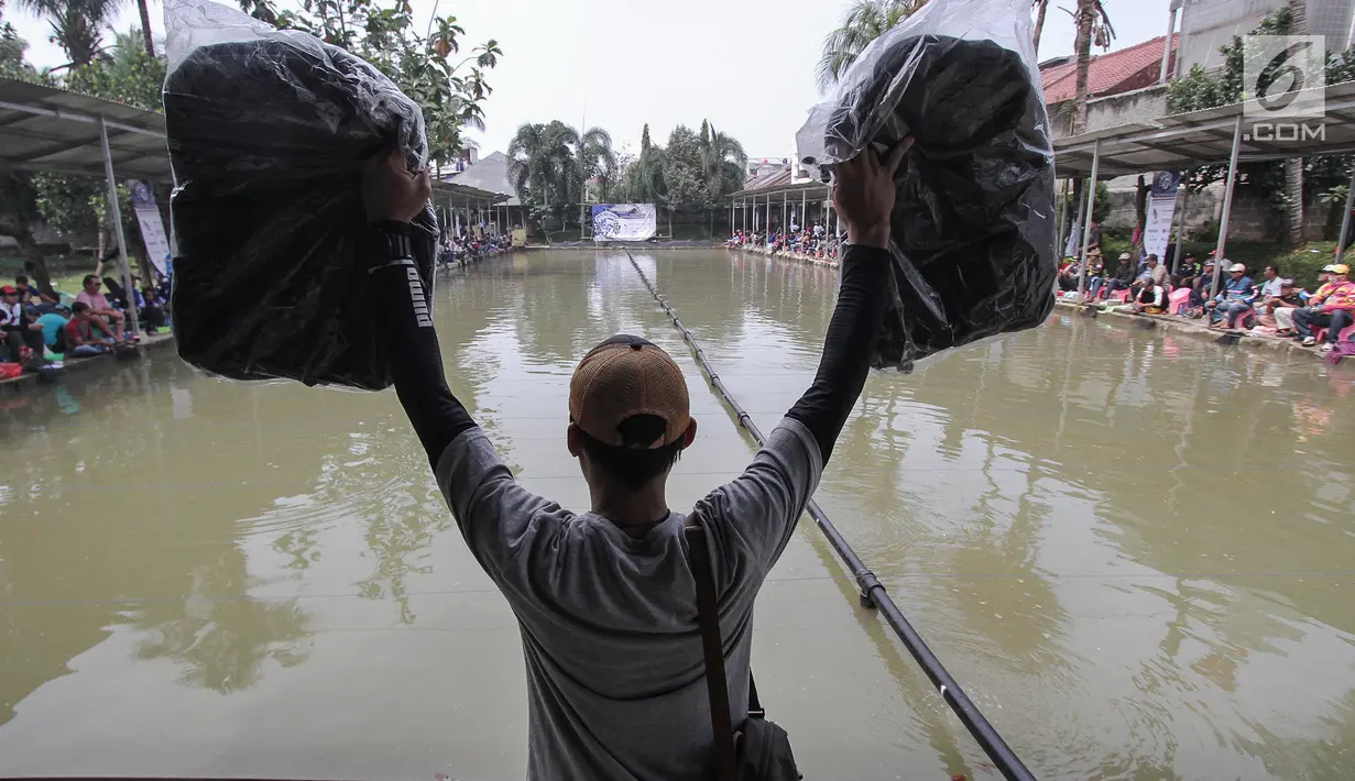 Panitia membagikan hadian kepada peserta turnamen Jurnalis Mancing Indonesia di Kolam Pemancingan Deluna, Depok, Sabtu (6/4). Turnamen yang diikuti 120 peserta se-Jabodetabek dan Bandung memperebutkan piala Menteri Desa PDTT dan total uang tunai Rp 32 juta. (Liputan6.com/HO/Eko)