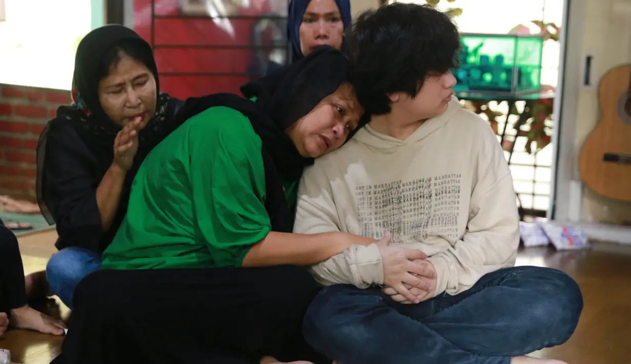 Istri Yon dengan menganakan baju warna hijau tampak belum ditinggal sang suami untuk selama-lamanya. Dari pantauan di rumah duka, ia tampak beberapa kali harus mengusap air matanya. (Adrian Putra/Bintang.com)