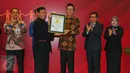 Mendagri Tjahjo Kumolo menerima piagam rekor MURI usai melakukan penandatangan kerja sama pemanfaatan data kependudukan dengan 100 pelaku usaha Bursa Efek Indonesia (BEI) di Gedung BEI, Jakarta, Selasa (22/11). (Liputan6.com/Angga Yuniar)