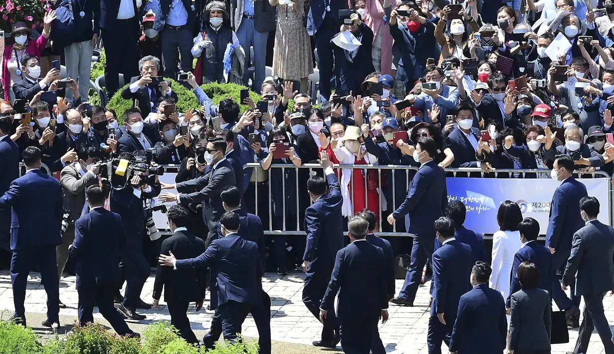 <p>Pendukung menyambut Presiden Korea Selatan Yoon Suk-yeol (tengah) saat dia tiba untuk upacara pelantikannya di Majelis Nasional, Seoul, Korea Selatan, Selasa (10/5/2022). Yoon menjabat sebagai presiden baru Korea Selatan dengan sumpah untuk mengejar penyelesaian negosiasi program nuklir Korea Utara dan tawaran "rencana berani" untuk meningkatkan ekonomi Pyongyang jika meninggalkan senjata nuklirnya. (Kim Min-hee/Pool Photo via AP)</p>