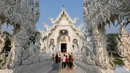 Sejumlah turis saat melakukan tur di Wat Rong Khun atau kuil putih di Provinsi Chiang Mai, Thailand, Jumat (4/3). Kuil Putih dirancang oleh seniman visual Thai Chalermchai Kositpipat. (REUTERS / Jorge Silva)