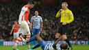 Striker Arsenal, Olivier Giroud, menyundul hingga menyebabkan bek QPR, Nedum Onuoha, terjatuh saat laga boxing day Premier League di Stadion Emirates, Inggris, Jumat (26/12/2014). (AFP/Glyn Kirk)