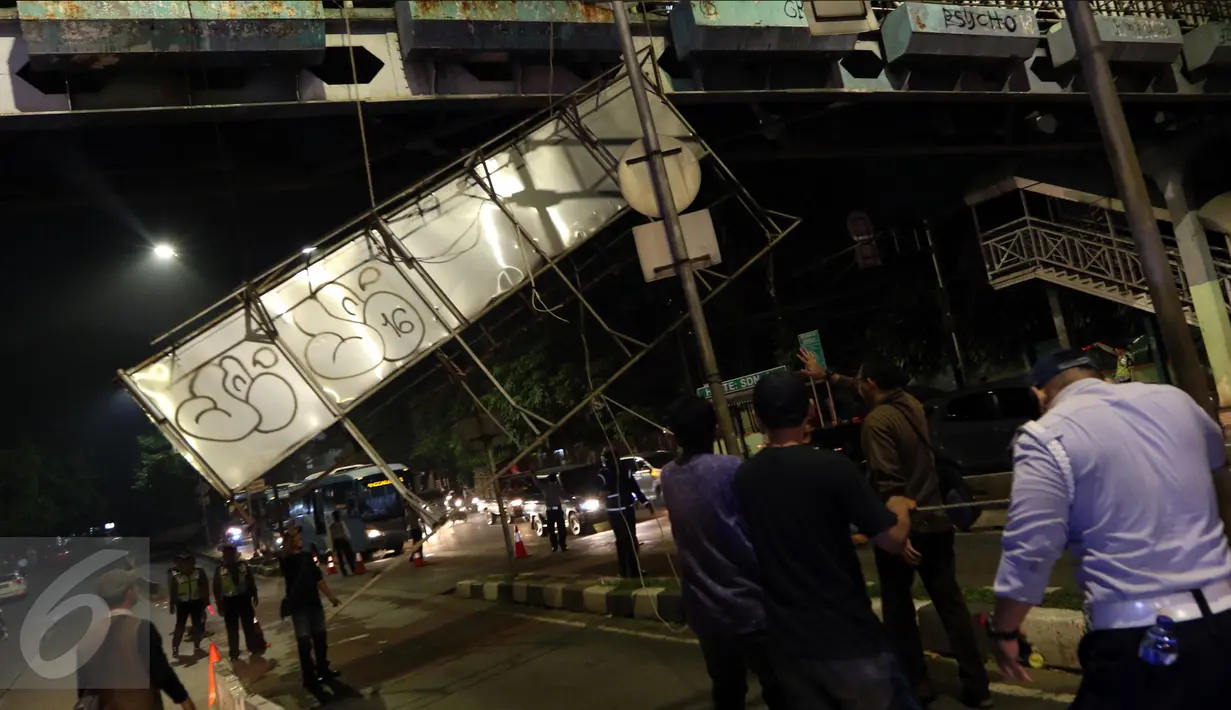 Petugas menurunkan papan reklame di jembatan penyeberangan orang (JPO) di Jalan Warung Buncit Raya, Jakarta, Jumat (7/10). Dinas Perhubungan DKI akan membongkar 74 reklame lain yang berada di jembatan penyeberangan orang. (Liputan6.com/Helmi Afandi)