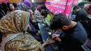 Tradisi henna (atau lebih dikenal sebagai Mehndi dalam bahasa Urdu) di Pakistan merupakan bagian tak terpisahkan dari perayaan budaya, terutama dalam pernikahan dan hari raya keagamaan. Tampak dalam foto, para penata kecantikan, di sebelah kiri, melukis 'Henna' tradisional di tangan pelanggan untuk perayaan Idul Fitri, yang menandai berakhirnya bulan suci Ramahan, di Rawalpindi, Pakistan, Rabu, 18 Maret 2026. (AP Photo/Anjum Naveed)