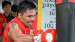 Petinju Manny Pacquiao saat berlatih di gym di Manila, (17/5). Pacquiao yang juga senator Filipina akan bertanding pada kelas welter dunianya melawan petinju Argentina Lucas Matthysse pada bulan Juli. (AFP Photo/Ted Aljibe)