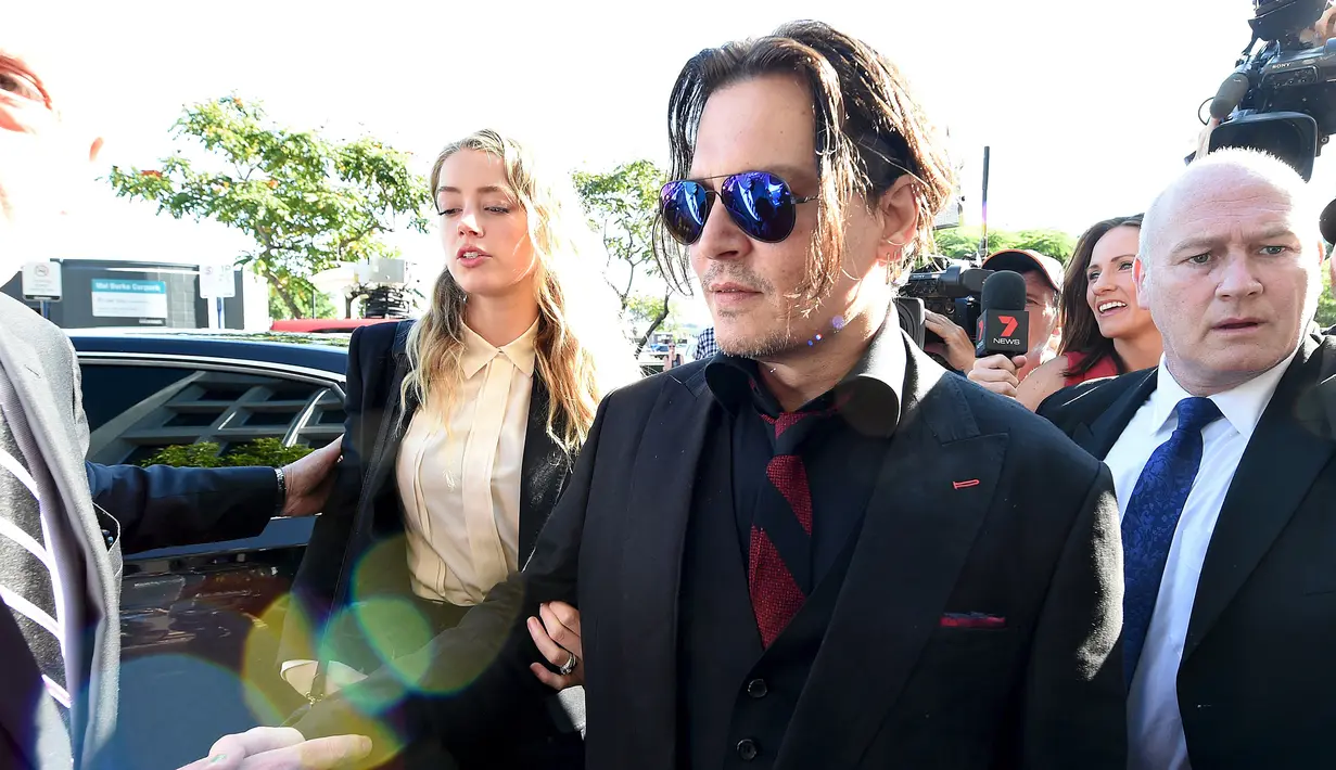 Aktor Johnny Depp dan istri Amber Heard berjalan masuk ke Pengadilan Southport Magistrates, Gold Coast Australia, Senin (18/4/2016). Depp dan Amber Heard menghadapi sidang pengadilan atas impor ilegal anjing pasangan ke Australia. (REUTERS/Dave Hunt/AAP)