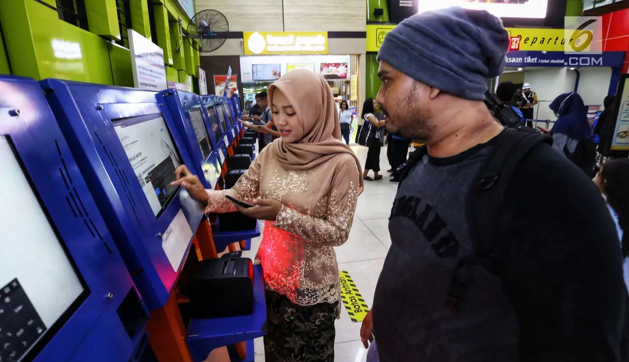 Petugas frontliner membantu calon penumpang membeli tiket di Stasiun Gambir, Jakarta, Minggu (21/4). PT KAI Daop 1 Jakarta mewajibkan petugas frontliner wanita dan pria mengenakan kebaya dan batik untuk menyambut Hari Kartini. (Liputan6.com/Johan Tallo)