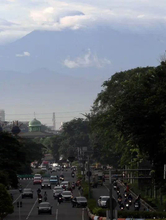<p>Kawasan gunung Gede-Pangrango terlihat samar menjadi latar belakang pemandangan di Jalan Benyamin Sueb, Kemayoran, Jakarta, Kamis (18/2/2021). Jika cuaca cerah, kawasan gunung Gede-Pangrango bisa terlihat dengan jelas dari atas jembatan layang Jalan HBR Motik. (Liputan6.com/Helmi Fithriansyah)</p>
