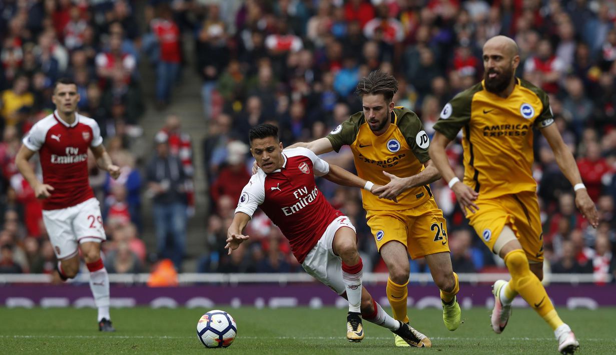 Pemain Arsenal, Alexis Sanchez (kiri) berusaha menjauh dari kejaran pemain Brighton pada lanjutan Premier League di Emirates Stadium, London, (1/10/2017). Arsenal menang 2-0. (AFP/Adrian Dennis) 